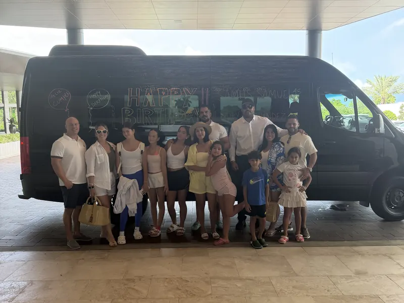 Family birthday group with kids standing in front of the Cruise Shuttle Miami Sprinter decorated with Happy Birthday